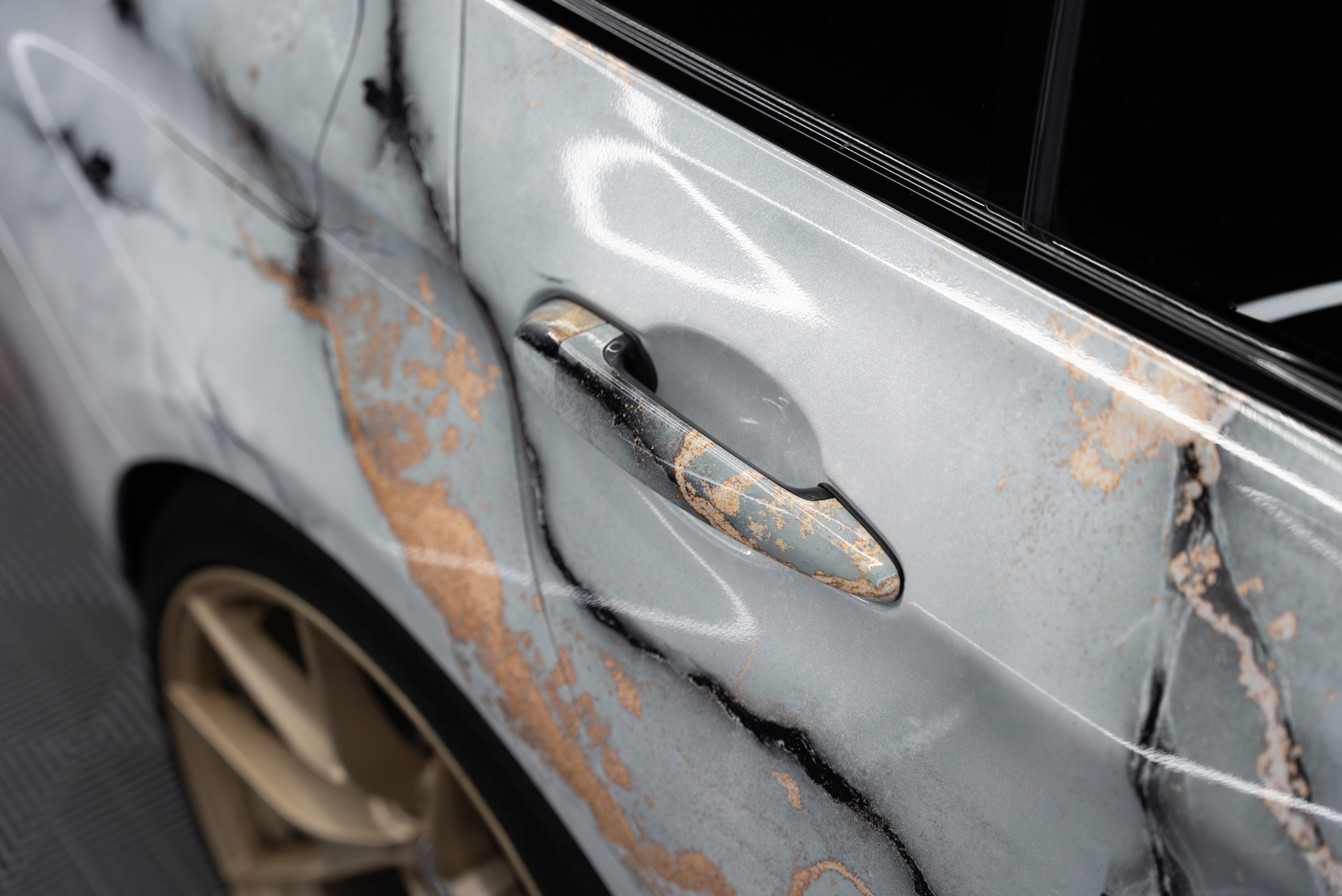 Close-up of a door handle on a marble-wrapped car